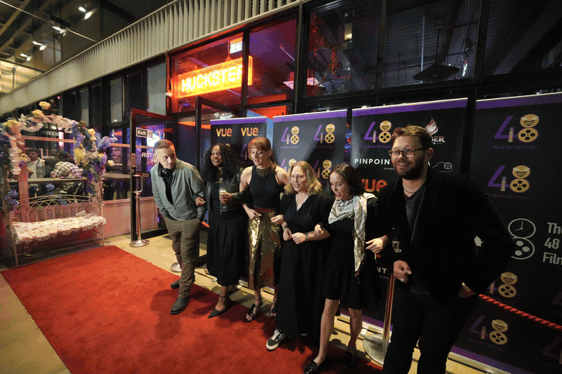 Animated red carpet sequence of a film team posing and then breaking into laughter at the awards night